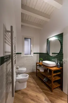 a bathroom with two toilets and a sink and a mirror at Cortile Del Greco Apartments in Palermo