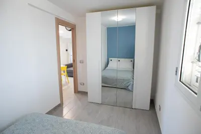 a bedroom with a mirror and a bed in it at Appartamento con terrazza in Isola delle Femmine