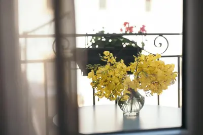 a vase filled with yellow flowers sitting on a table at La Casa di Ale in Palermo