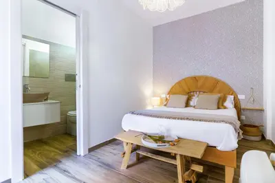 a bedroom with a large bed and a bathroom at Curtigghiu Mondello in Mondello