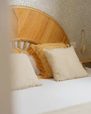 two pillows on a bed with a wooden headboard at Curtigghiu Mondello in Mondello