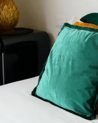 a green pillow sitting on top of a bed at Curtigghiu Mondello in Mondello