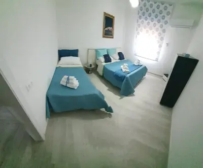 a bedroom with two beds and a window at Sea Holiday Orchidea in Palermo