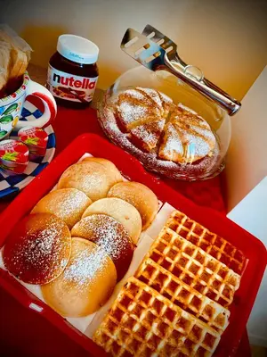a table with a tray of bread and waffles and syrup at Affittacamere Palermo Pirri in Palermo