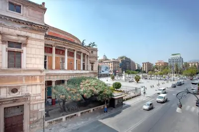 an old building on a city street with cars at The house Politeama Palermo Historic center in Palermo