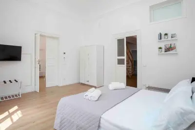 a white bedroom with two towels on a bed at The house Politeama Palermo Historic center in Palermo