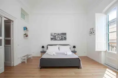 a bedroom with a bed in a white room at The house Politeama Palermo Historic center in Palermo