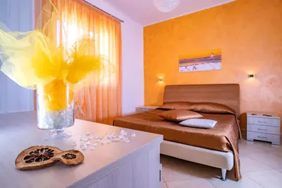 a bedroom with a bed and a vase of flowers on a table at B&B Pietre Preziose in Castelluzzo