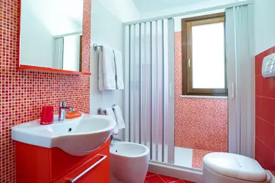 a red and white bathroom with a sink and a shower at B&B Pietre Preziose in Castelluzzo