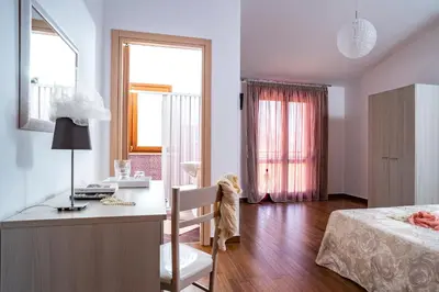 a bedroom with a desk and a bed and a window at B&B Pietre Preziose in Castelluzzo