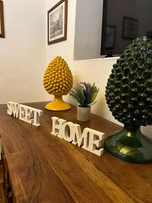 a table with two vases and a sign that reads sweet home at Cut' Home in Monreale