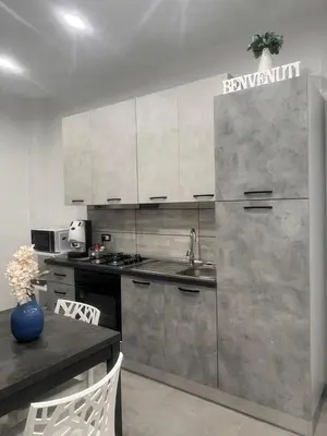 a kitchen with a stainless steel refrigerator and a table at La casetta di salvuccio in Palermo