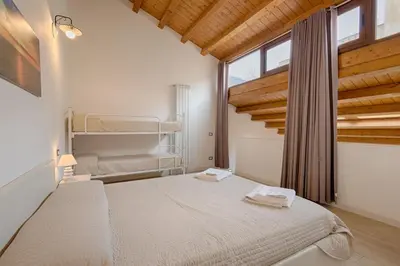 a bedroom with a large white bed with wooden ceilings at GuestHost - Il Piccolo Scrigno - Comfy & Central Studio x5 in Castellammare del Golfo