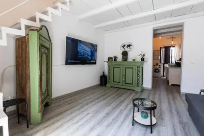 a living room with a tv on a wall at ELLY HOLIDAY HOUSE in Palermo