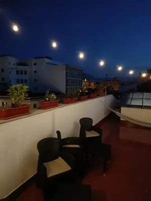 a balcony with two chairs on a roof at night at Mille Lire Peppe's Home in Palermo