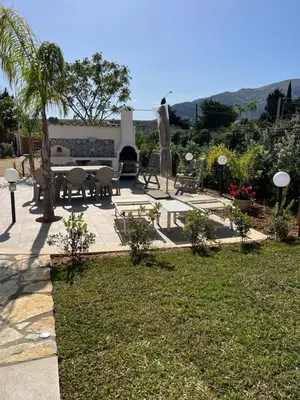 a park with a bench and a table and chairs at Scopello Guidaloca Villas in Scopello
