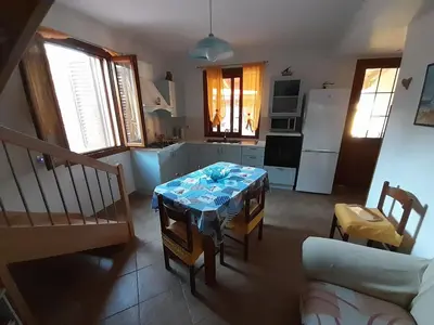 a living room with a table and a kitchen at Mediterraneo in Castellammare del Golfo