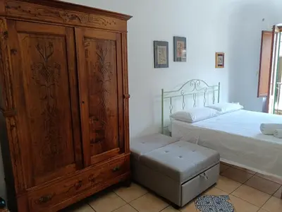 a bedroom with a large wooden cabinet next to a bed at Quiet and comfortable apartment in Palermo city centre in Palermo