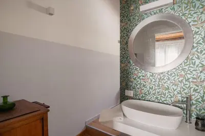 a bathroom with a white toilet and a mirror at Conte Ruggero Apartment by DomuSicily in Palermo