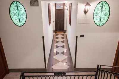 a hallway with a tile floor and two large windows at Conte Ruggero Apartment by DomuSicily in Palermo