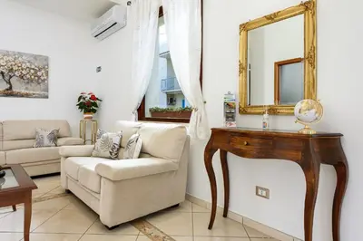 a living room with a mirror and a couch at Hotel La Darsena in San Vito lo Capo