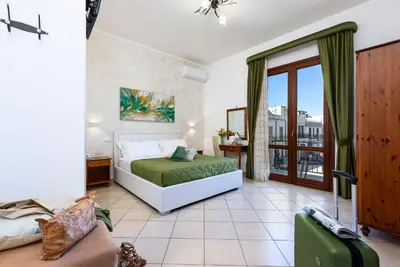 a bedroom with a bed and a large window at Hotel La Darsena in San Vito lo Capo
