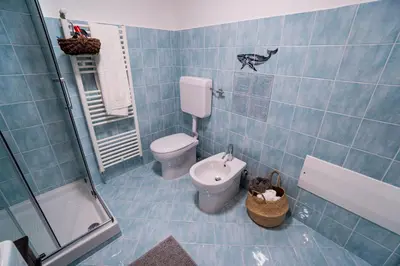 a blue tiled bathroom with a toilet and a sink at Solemar Sicilia - Palazzo Vetrano Centro Storico in Palermo
