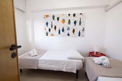two beds in a room with a painting on the wall at Apartment on the Beach - Large Terrace in Alcamo