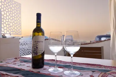 a bottle of wine and two wine glasses on a table at Apartment on the Beach - Large Terrace in Alcamo