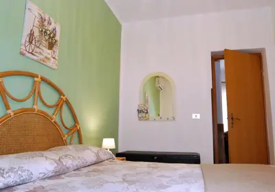 a bedroom with a bed and a mirror on the wall at Villa Rosetta vacanze al mare in Carini