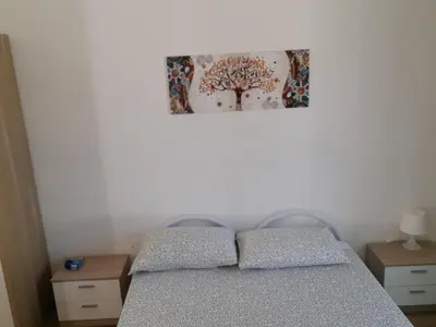 a bedroom with a bed and a picture on the wall at Villa Eufrosine in Palermo