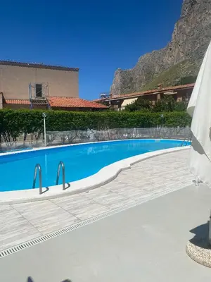a swimming pool with a mountain in the background at Villa Eufrosine in Palermo