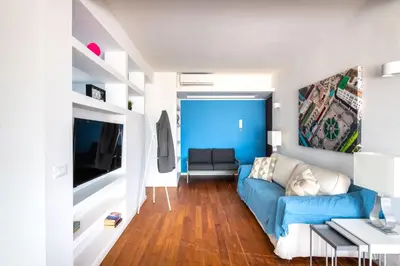 a living room with a blue couch and a tv at Vista sulle Cupole by Wonderful Italy in Palermo