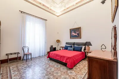 a bedroom with a red bed and a coffered ceiling at Lea's Luxury Art Apartment by Wonderful Italy in Palermo
