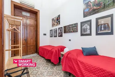two beds in a room with a red blanket at Lea's Luxury Art Apartment by Wonderful Italy in Palermo