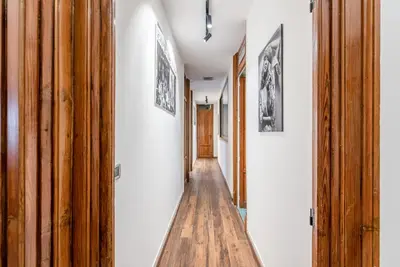 a hallway with white walls and a wooden floor at Lea's Luxury Art Apartment by Wonderful Italy in Palermo