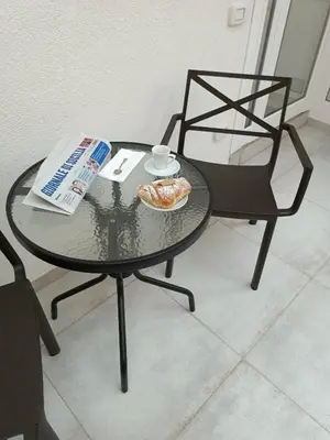 a table and chair with a book and a plate of food at Clio's House - Mondello in Mondello
