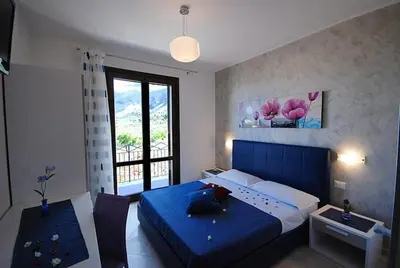 a bedroom with a blue bed and a window at La Chiocciola 2 Bed&Breakfast in Castelluzzo