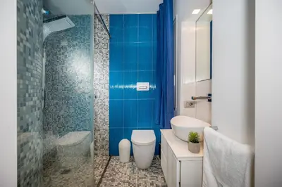 a bathroom with a toilet and a glass shower at Villa Sikelia in Alcamo