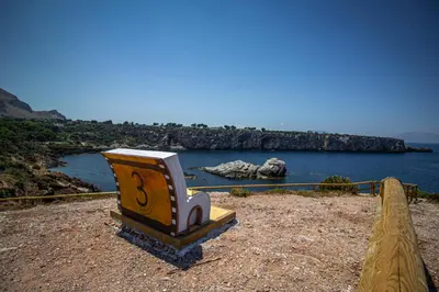 a bench sitting on the side of a body of water at B&B Marco Polo in Terrasini