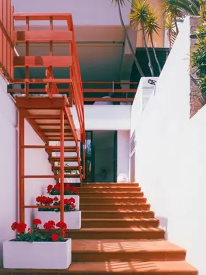 a staircase leading to a building with red flowers at Sea apartment 1 in Palermo