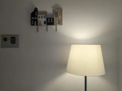 a lamp in a room with a wall with houses on it at Iverlid Ballarò in Palermo