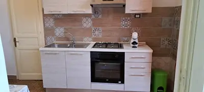 a small kitchen with a stove and a sink at Holiday House Marconi in Castellammare del Golfo