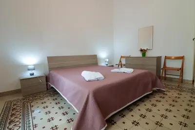 a bedroom with a bed with two towels on it at Holiday House Marconi in Castellammare del Golfo