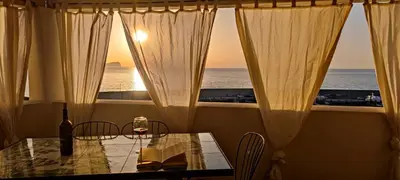 a dining room table with a view of the ocean at Casa del Pescatore Terrasini in Terrasini