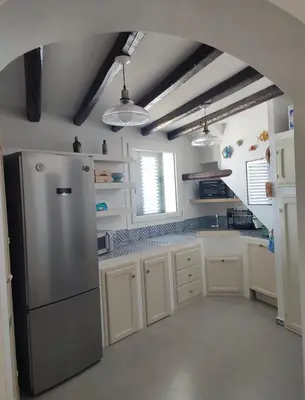a kitchen with a stainless steel refrigerator and white cabinets at Casa del Pescatore Terrasini in Terrasini