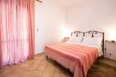 a bedroom with a bed with a red and white blanket at Villa Scirocco Macari in Macari