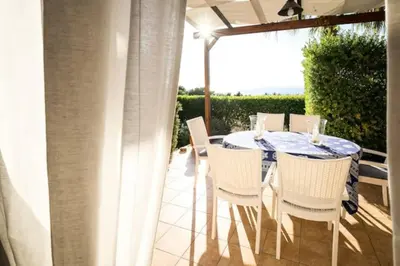 a dining table and chairs on a patio at Villa Scirocco Macari in Macari