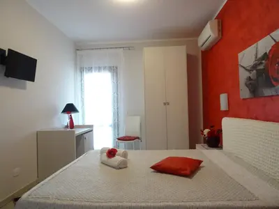 a bedroom with a bed with a red wall at B&B Le Onde Del Mare in San Vito lo Capo