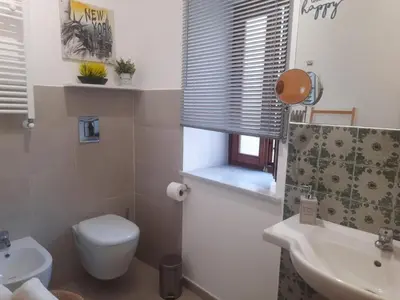 a bathroom with a white toilet and a sink at Peri Peri House - Palermo Centro in Palermo